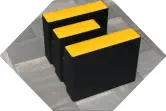 Sitzhocker in Form eines abstarkten E steht auf Steinboden