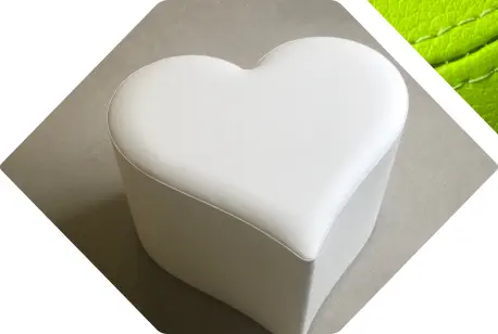 herzförmiges Sitzelement mit weißem Kunstlederbezug
