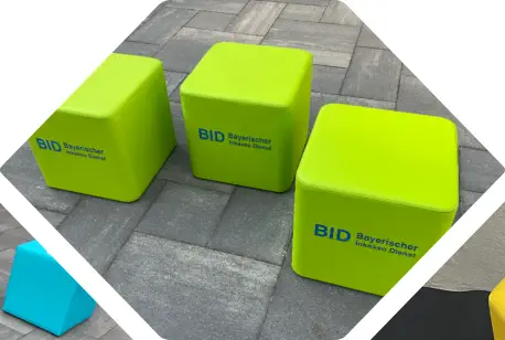 grüne Würfelhocker Elemente mit blauer BID Bestickung