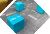 3 blaue ESET Würfelhocker stehen im Freien