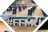 Buchstaben #FFMUC stehen aufrecht vor Stühlen bei einem Event 