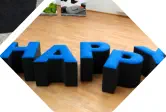 Buchstaben HAPPY zum darauf sitzen stehen im Foyer