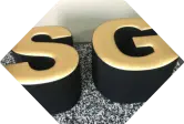 goldene Buchstaben S und G stehen vor einer Wand