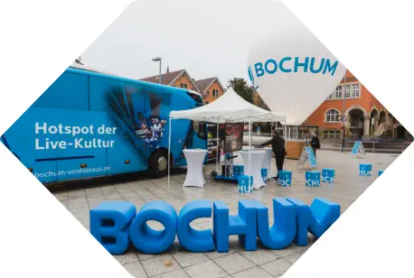 blaue Sitzbuchstaben BOCHUM stehen aufrecht auf einem Marktplatz