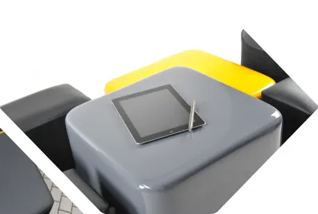 IPad mit Stift liegt auf einem glänzend lackierten grauen Tischelement